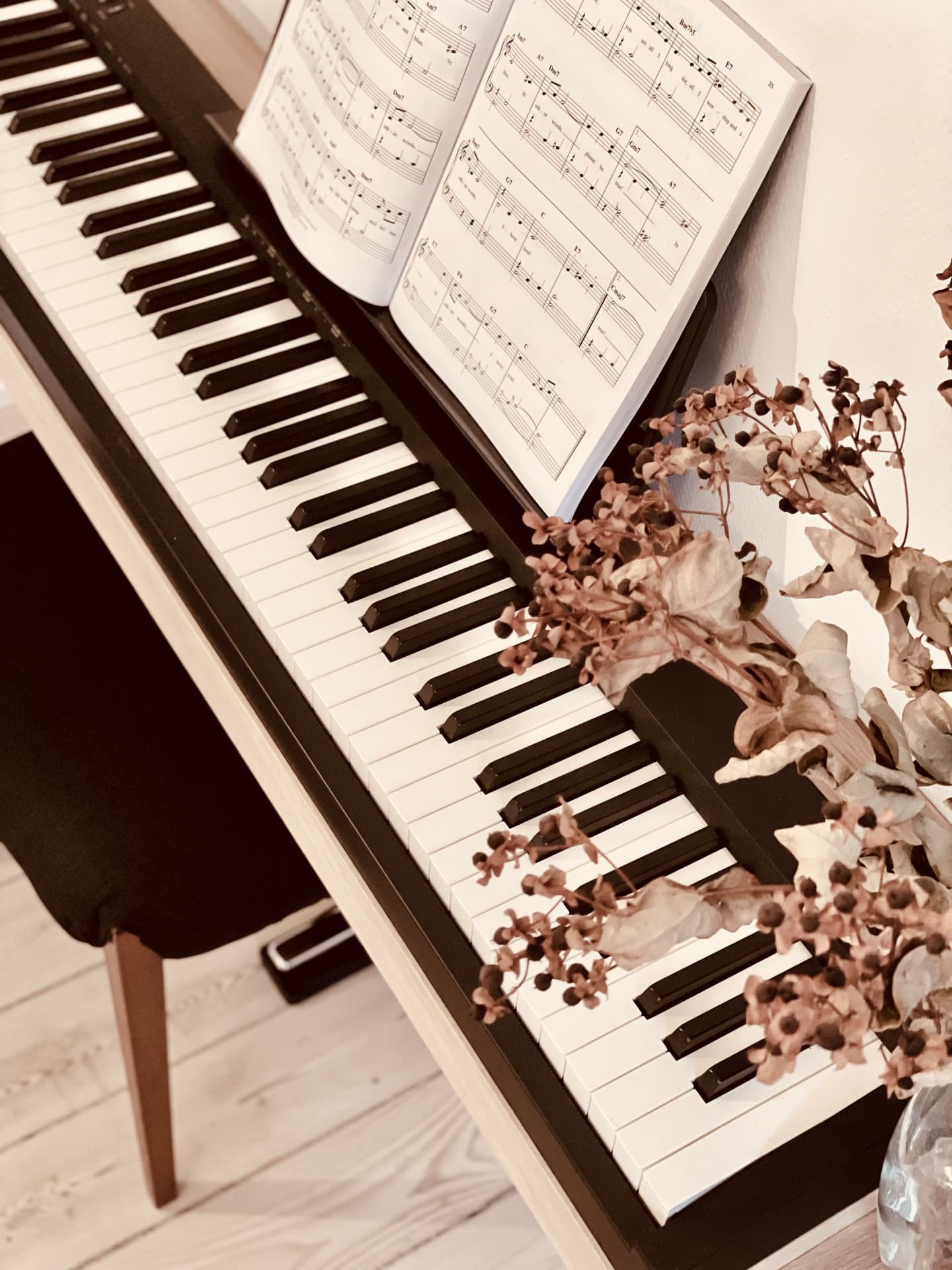 Close-up of digital piano keys on an oak wall-mounted piano frame in a Scandinavian interior
