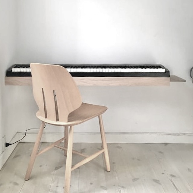 Customer photo of a floating oak piano shelf with a light wooden chair in a Nordic home